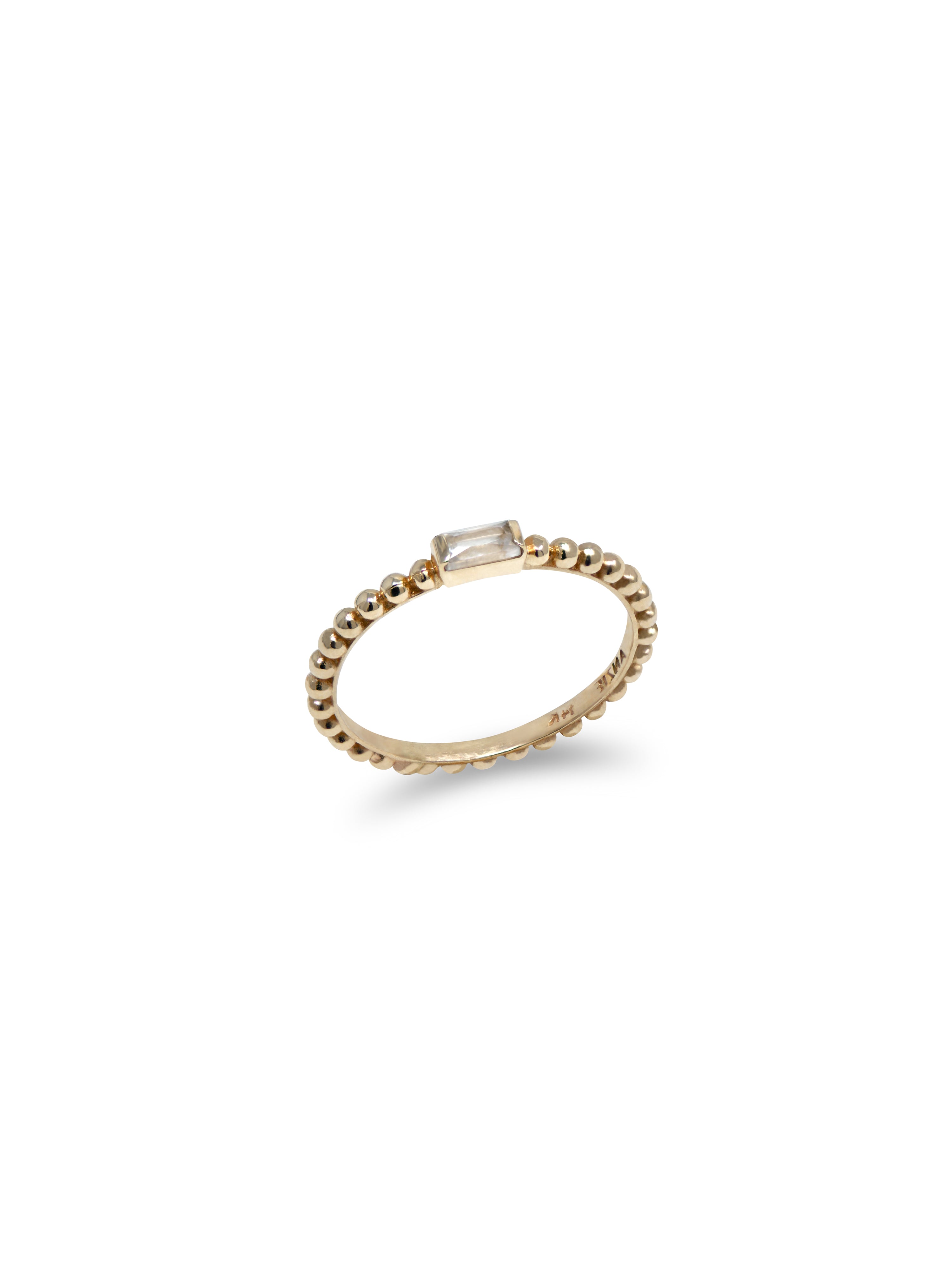 A gold band ring with a stackable design and a clear stone set in the center, surrounded by a textured band.