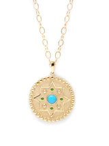 Gold star medallion with turquoise center stone and emerald accent stones on an open link gold chain