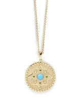 Gold star medallion with turquoise center stone and emerald accent stones on a thin gold chain